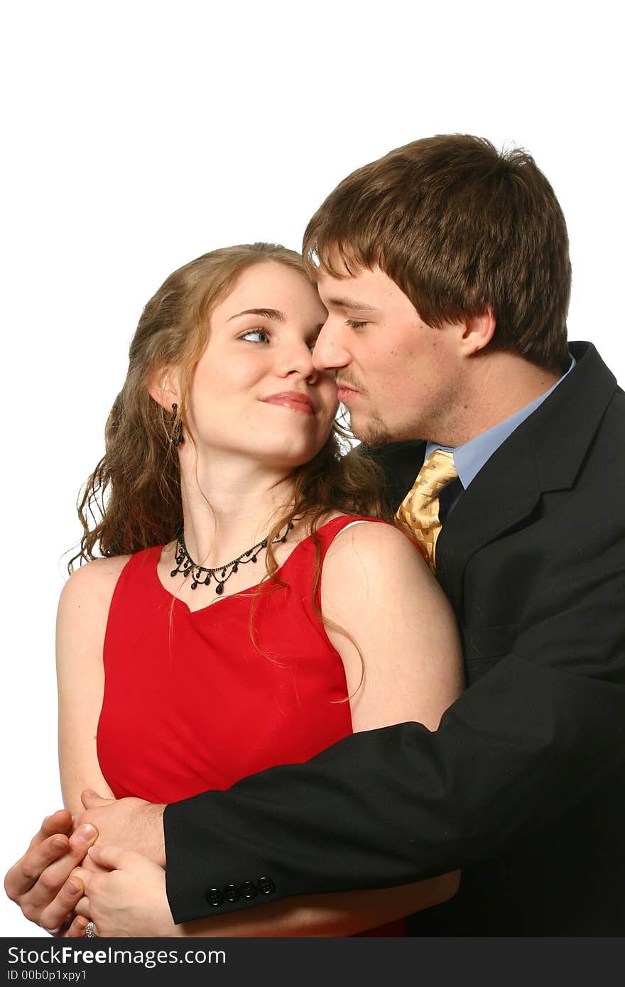 Handsome young man embraces beautiful young lady in a red dress isolated on white space. Handsome young man embraces beautiful young lady in a red dress isolated on white space