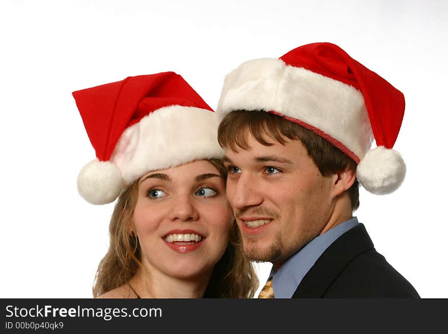 Young man and beautiful young lady with santa hats isolated on white space. Young man and beautiful young lady with santa hats isolated on white space