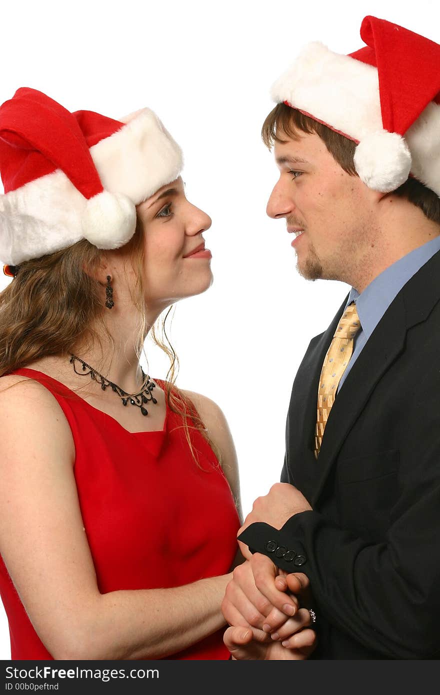 Young smiling couple wearing Santa hats at Christmas. Young smiling couple wearing Santa hats at Christmas