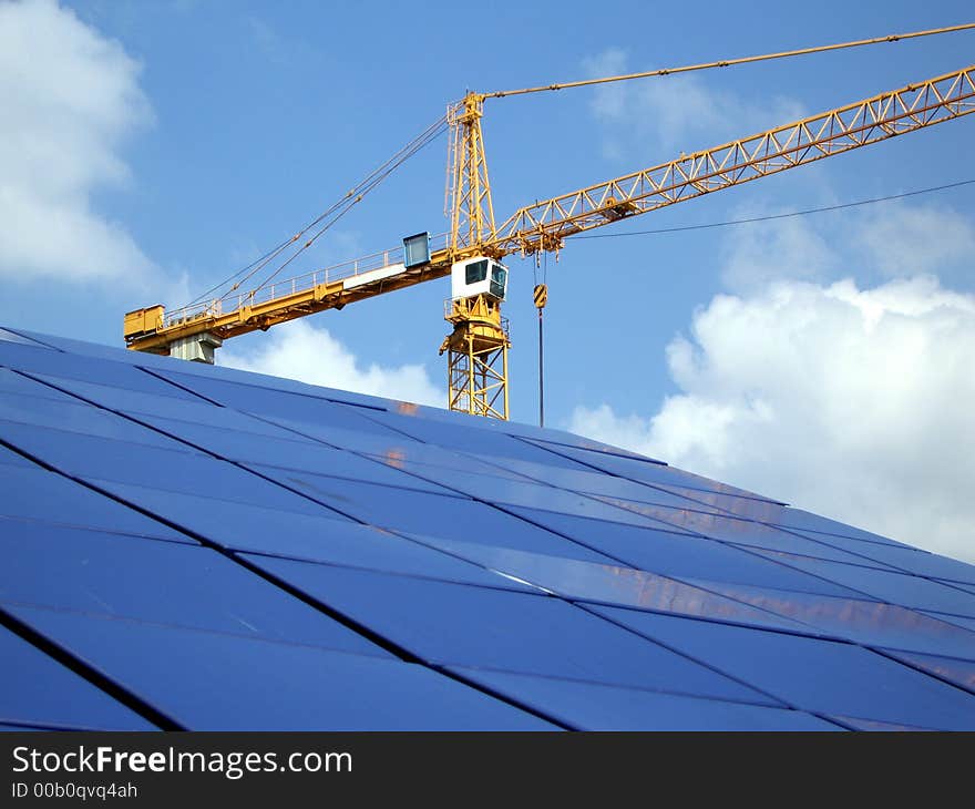 Crane at a construction site and its reflection off of blue tiles. Levels adjusted and logos removed in Photoshop. Crane at a construction site and its reflection off of blue tiles. Levels adjusted and logos removed in Photoshop.