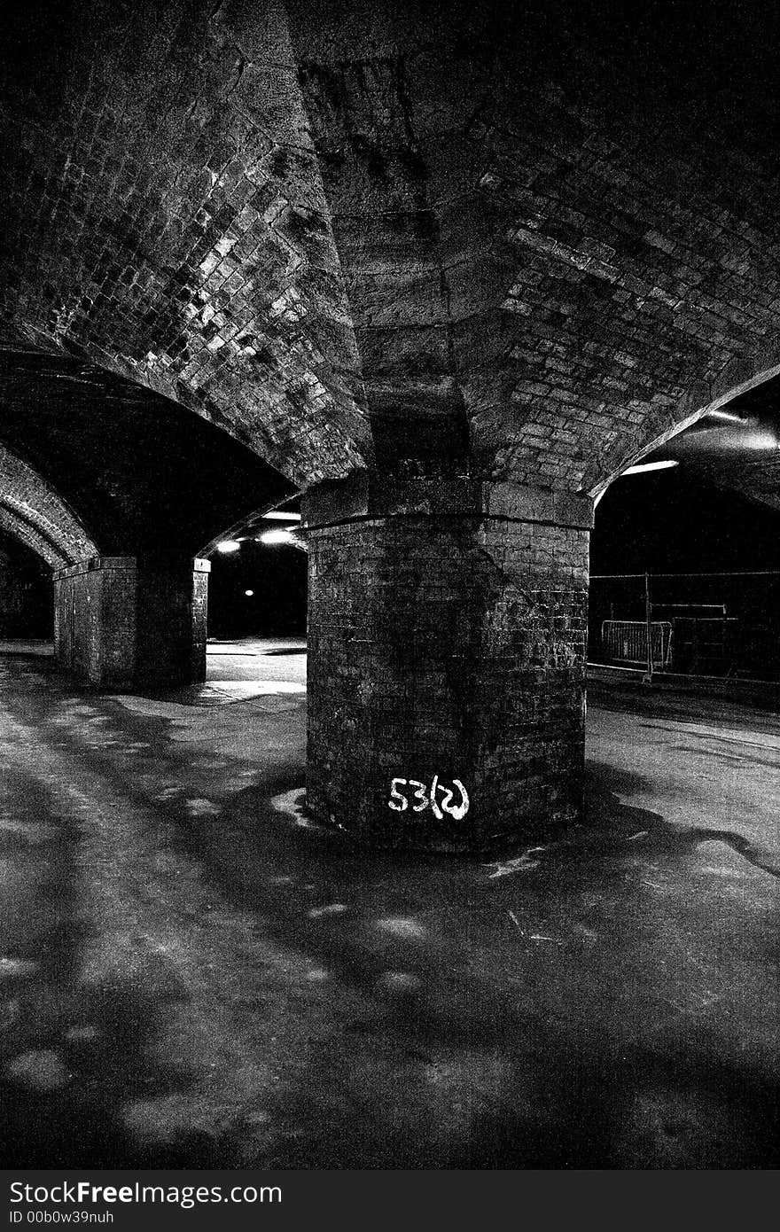 Central arch of old railway viaduct taken in black and white