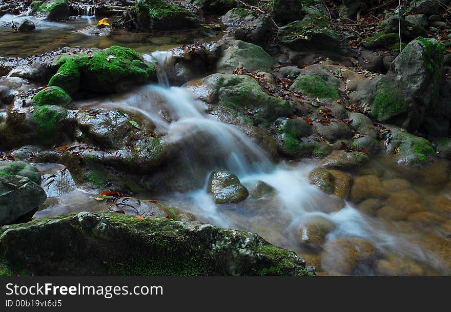 Stream in the woods wih rocks and silky flowing water