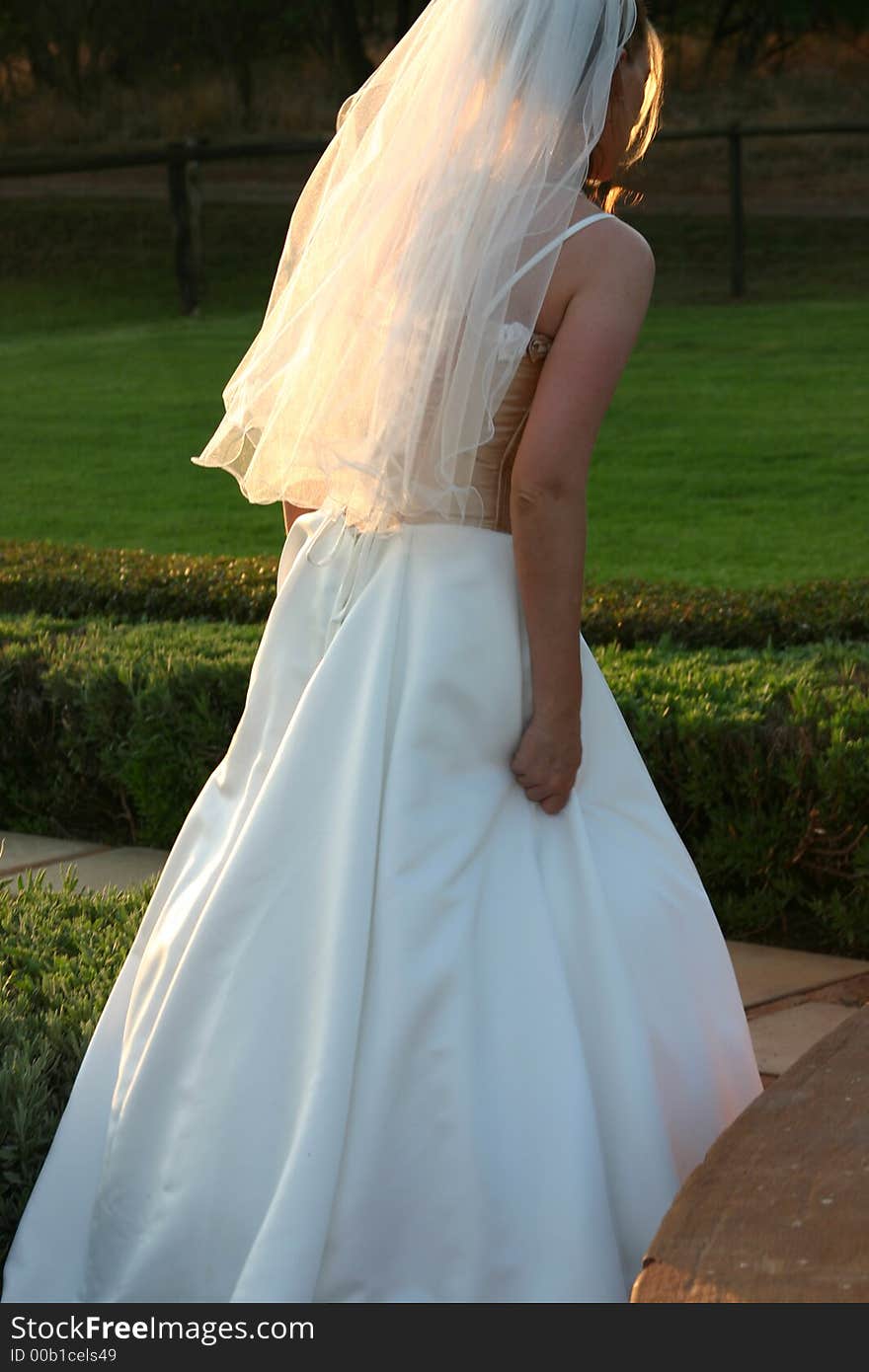 Beautiful blonde bride walking in the garden at the wedding venue. Beautiful blonde bride walking in the garden at the wedding venue.