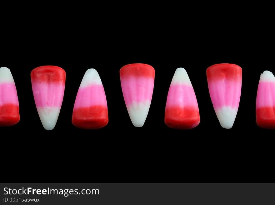 Pink candy corn line on a black background. Pink candy corn line on a black background