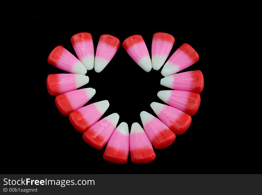 Pink candy corn heart on a black background