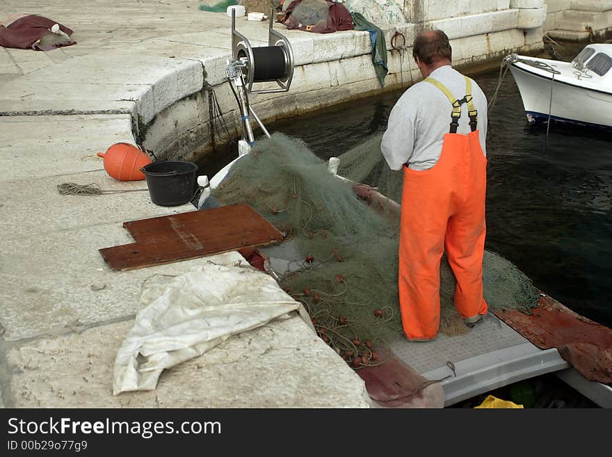 Croatian fisherman is preparing a net for fishing