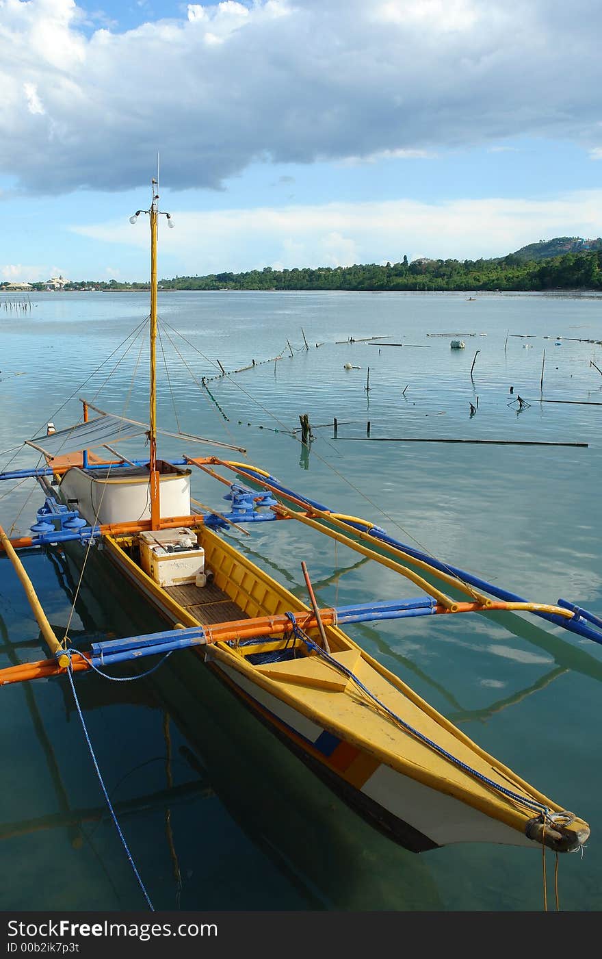 Southeast Asian colorful fishermen�s boat (bangka) under a majestic tropical sky and cloudscape. Southeast Asian colorful fishermen�s boat (bangka) under a majestic tropical sky and cloudscape.