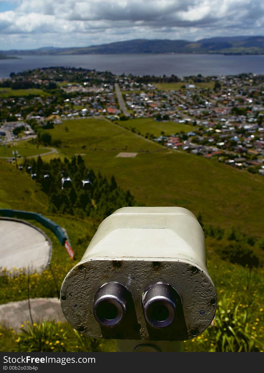 Tourist telescope overlooking the city, lake and distant mountains with emphasis on the telescope by using a shallow DOF. Tourist telescope overlooking the city, lake and distant mountains with emphasis on the telescope by using a shallow DOF