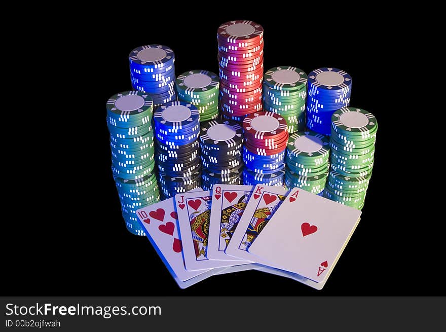 Royal Flush, hearts, with chips. Blue lighting from left hand side, isolated on black.