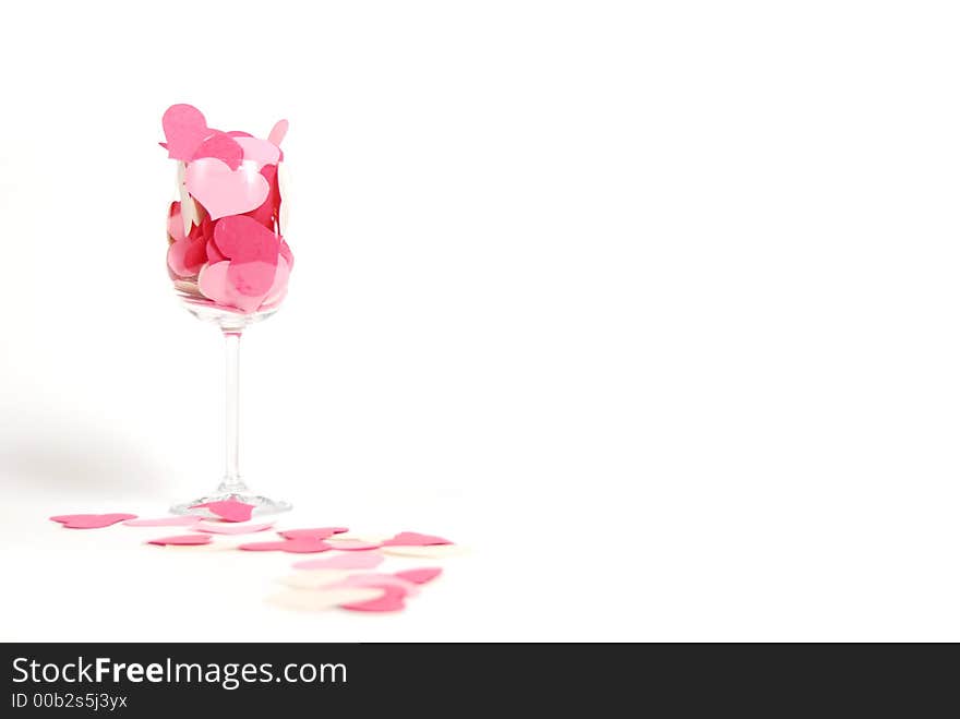 Cutout paper hearts aranged in a wine glass on a pure white background. Cutout paper hearts aranged in a wine glass on a pure white background