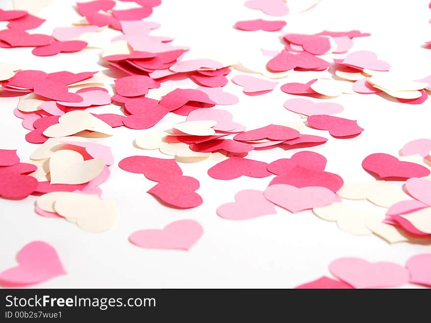 Red, pink and white paper hearts scattered on a white background. Red, pink and white paper hearts scattered on a white background