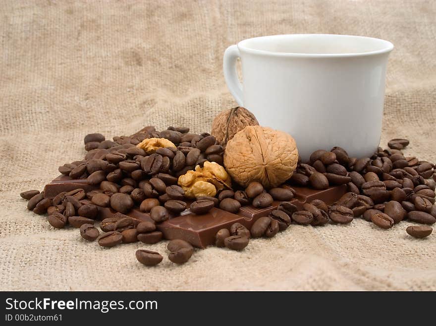 Cup of coffee, walnuts, coffee beans and chocolate