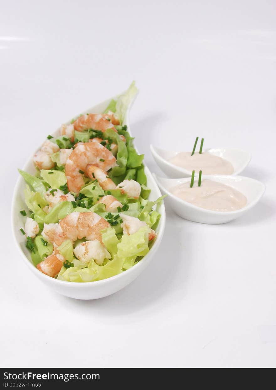 Shrimp salad in a white exclusives plates with sauce