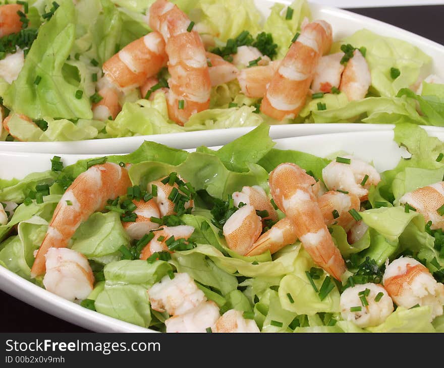 Shrimp salad in a white exclusives plates with sauce