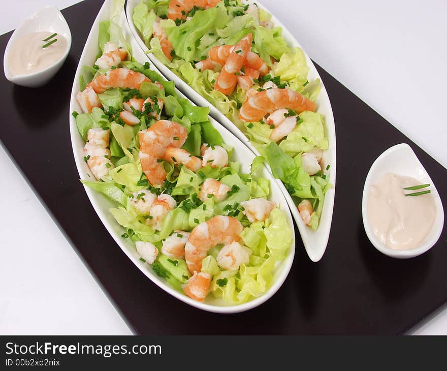 Shrimp salad in a white exclusives plates with sauce