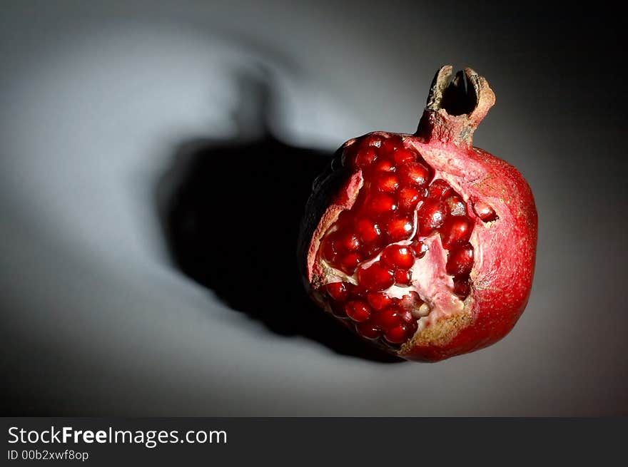 Ripe pomegranate in a ray of light