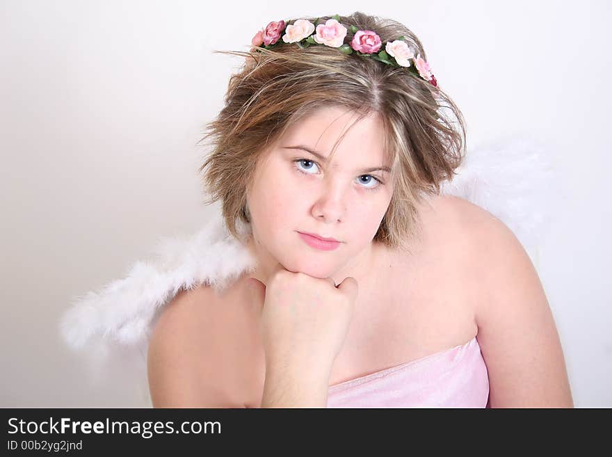 A beautiful teen angel with soft features and roses in her hair. A beautiful teen angel with soft features and roses in her hair.