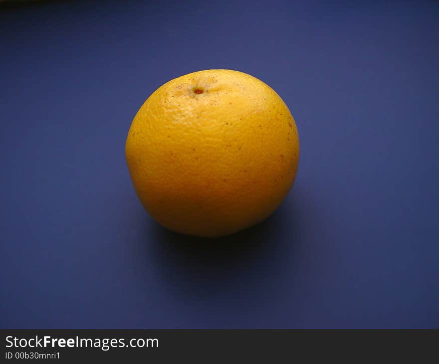 Single Grapefruit on blue background with lighting effects.