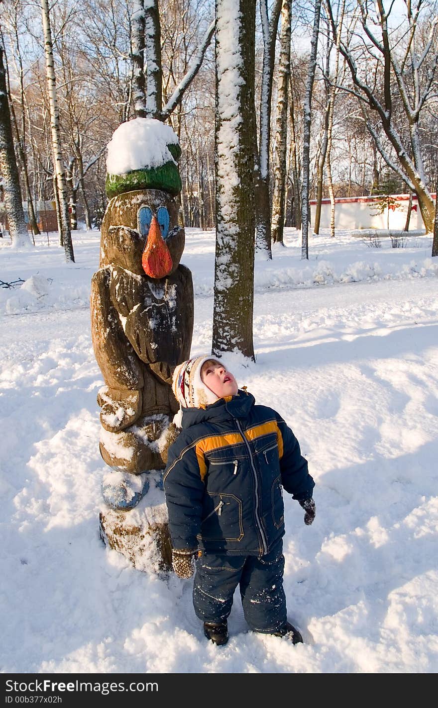 Opened mouth boy looking up at winter park landscape. Opened mouth boy looking up at winter park landscape