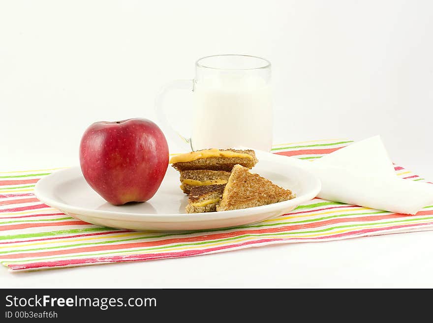 Brown bread,cheese,apple,milk and a colorful mat with a sail boat napkin make a nutritious lunch or dinner special for the little ones. Brown bread,cheese,apple,milk and a colorful mat with a sail boat napkin make a nutritious lunch or dinner special for the little ones.