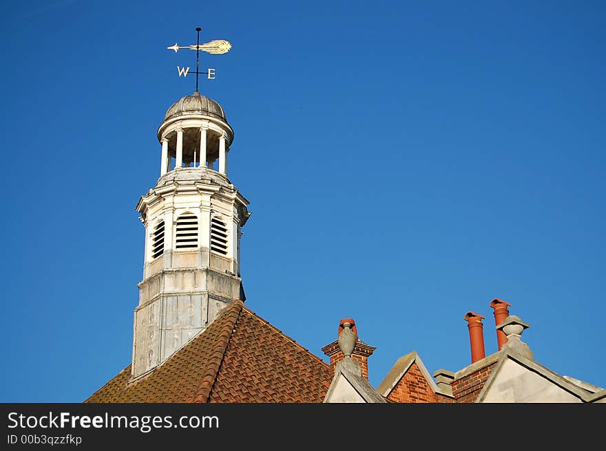 weather-vane on top of a tower pointing west. weather-vane on top of a tower pointing west