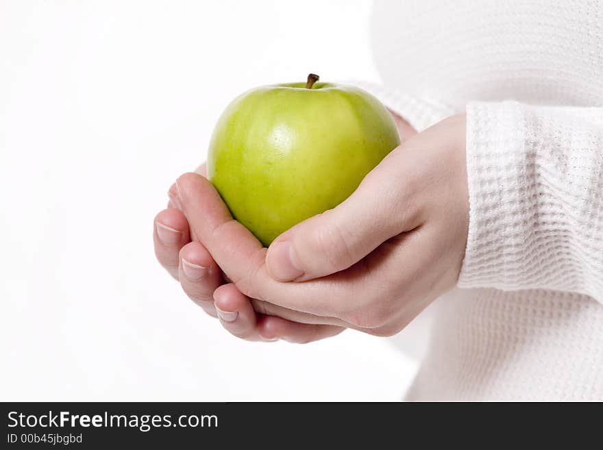 Womans hands holding a grannysmith green apple