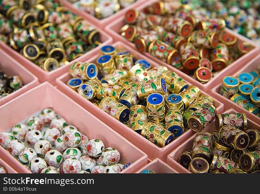 Arrayed boxes containing different types of chinese beads. Narrow DoF.