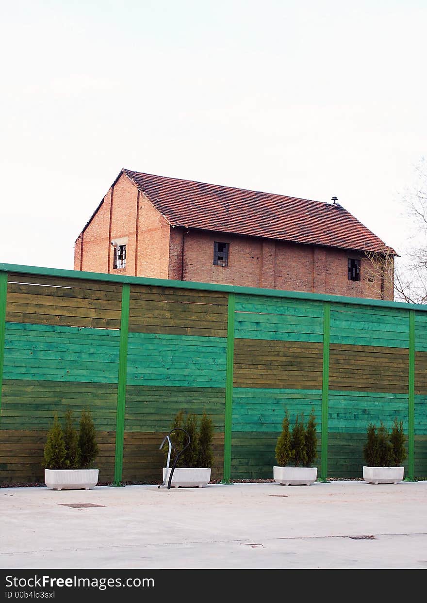 Red house behind wooden green fence