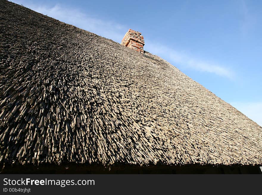 Reedy roof with chimney from red bricks