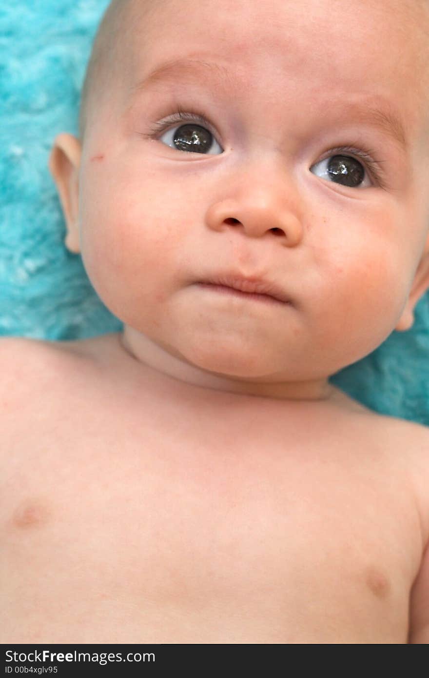 Image of a beautiful baby boy lying on a blue blanket. Image of a beautiful baby boy lying on a blue blanket