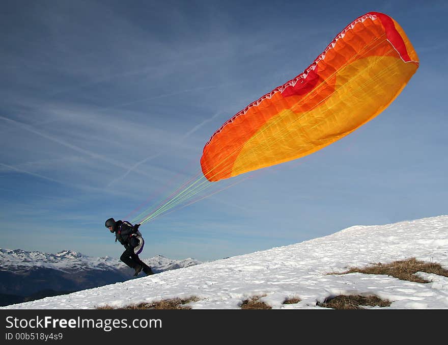 Paraglider takes off from the mountain to fly over the valley