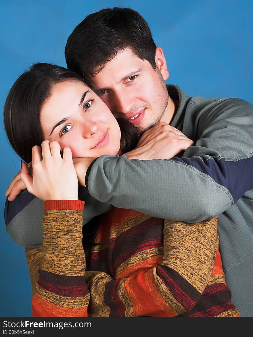 Young happy couple smiling on blue background