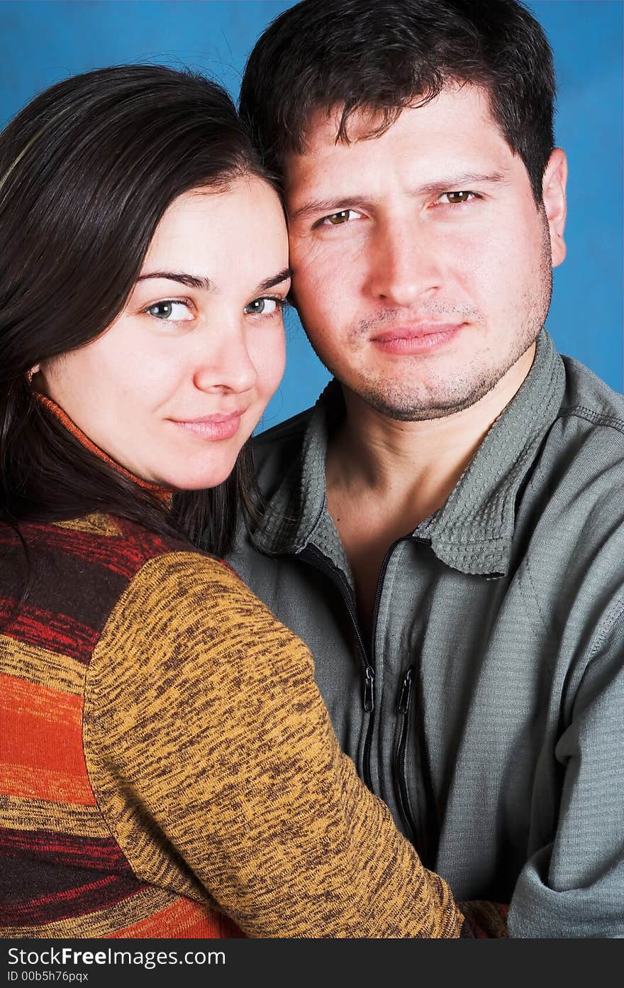 Young happy couple smiling on blue background. Young happy couple smiling on blue background