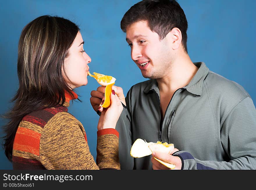 Young couple eat an orange. Young couple eat an orange