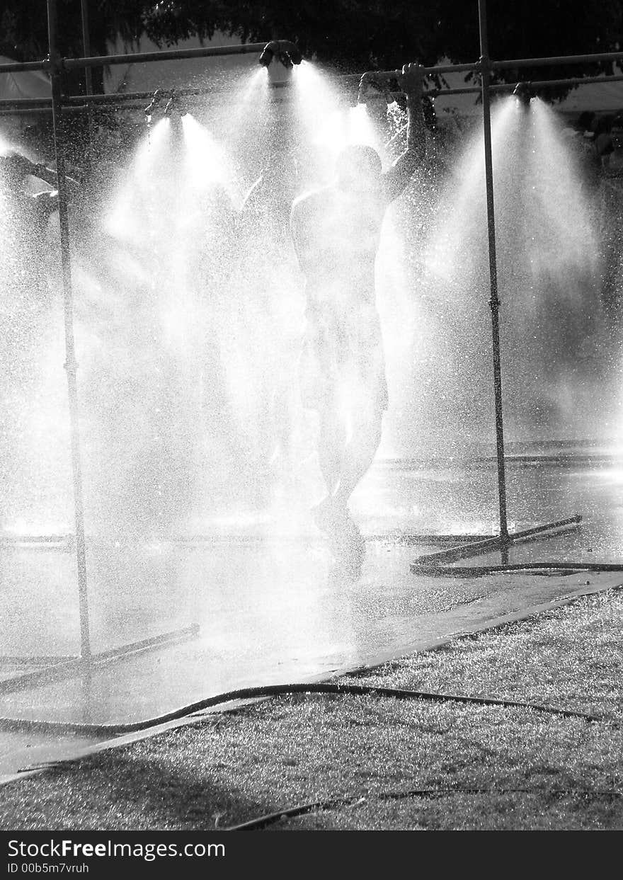 A runner cooling off in the showers after finishing a marathon. A runner cooling off in the showers after finishing a marathon