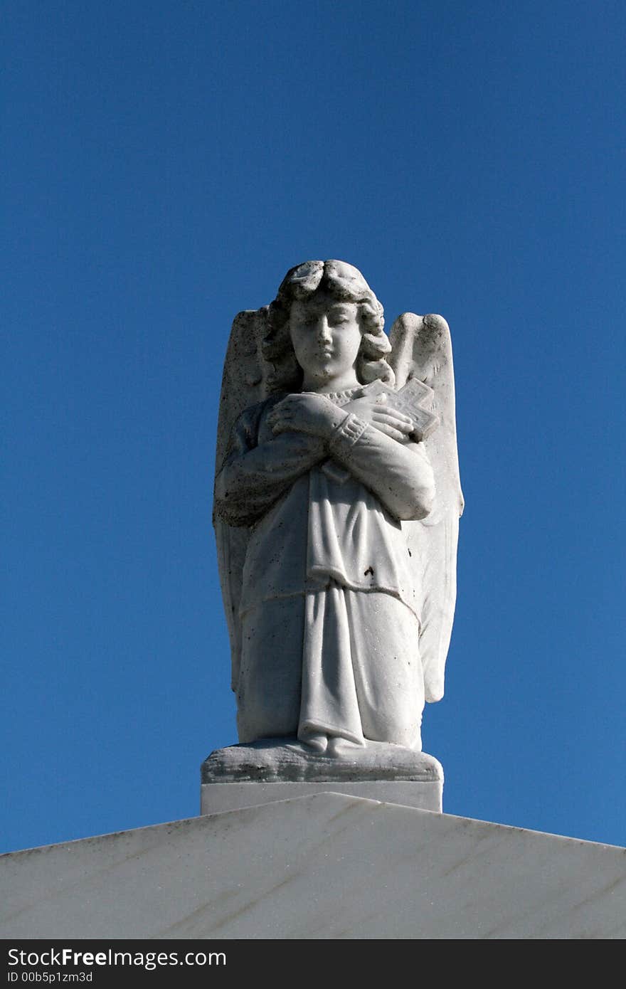 Angel with a cross on top of a tomb