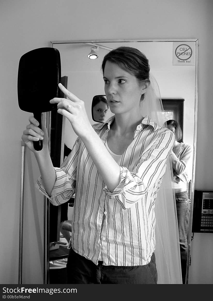 Bride Examining Her Reflection With Veil At Beauty Salon