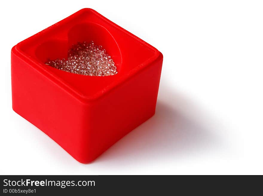 Red heart-shaped box with white glass beads, on white background and with copy space