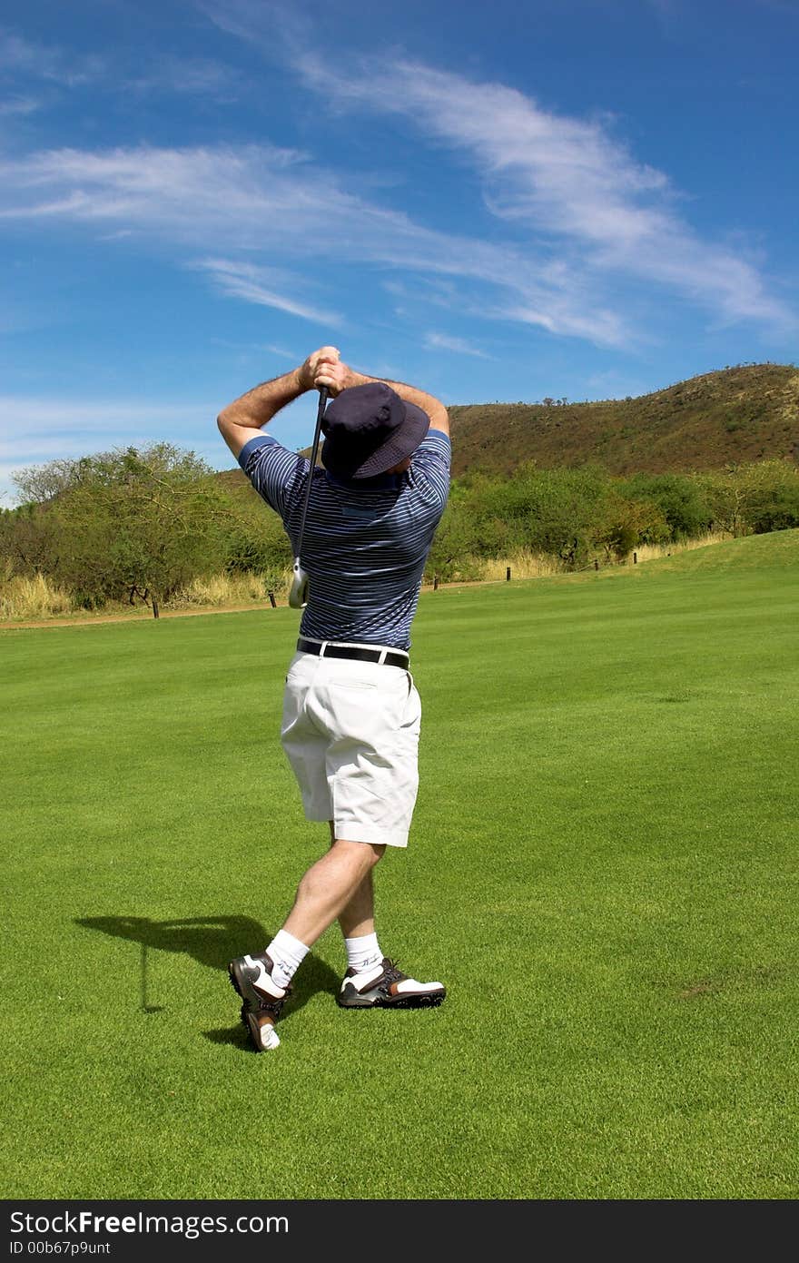 Golfer hitting the ball from the fairway. Golfer hitting the ball from the fairway.