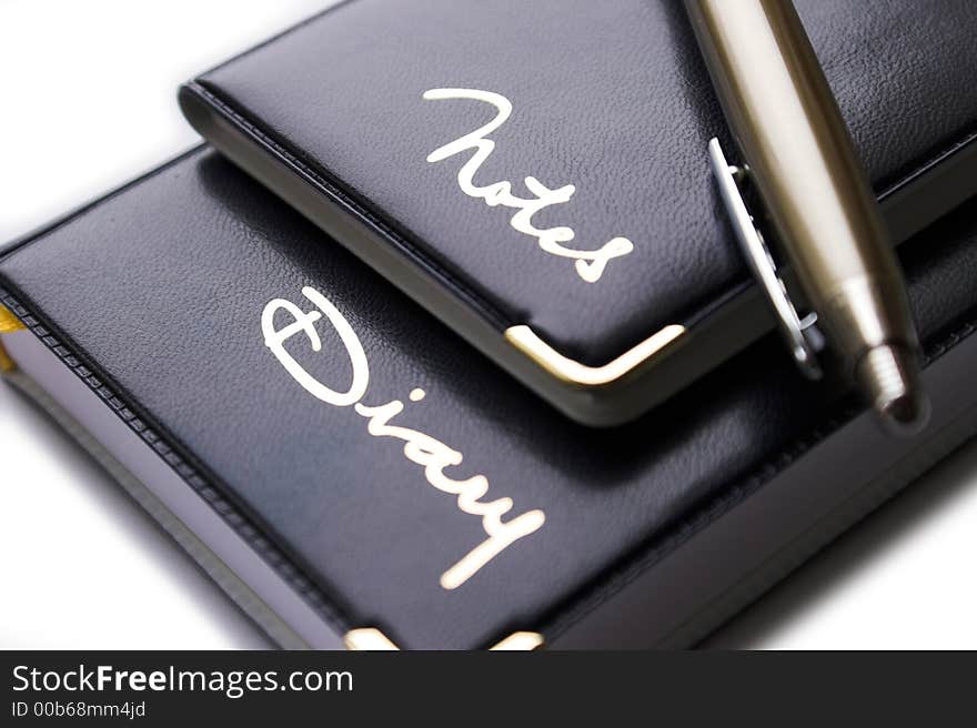 Office supplies: black notes, diary and metal pen. Office supplies: black notes, diary and metal pen.