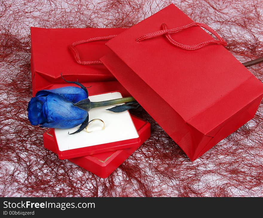 Gold ring on a gift box with blue rose for valentine�s day