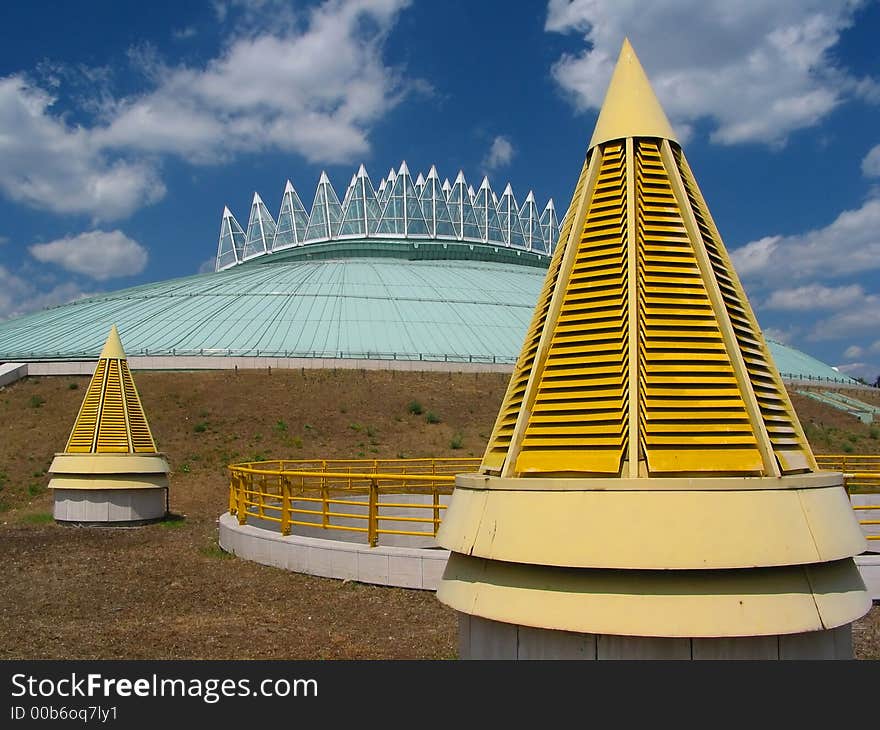 Yellow cones, blue sky with an amazing building