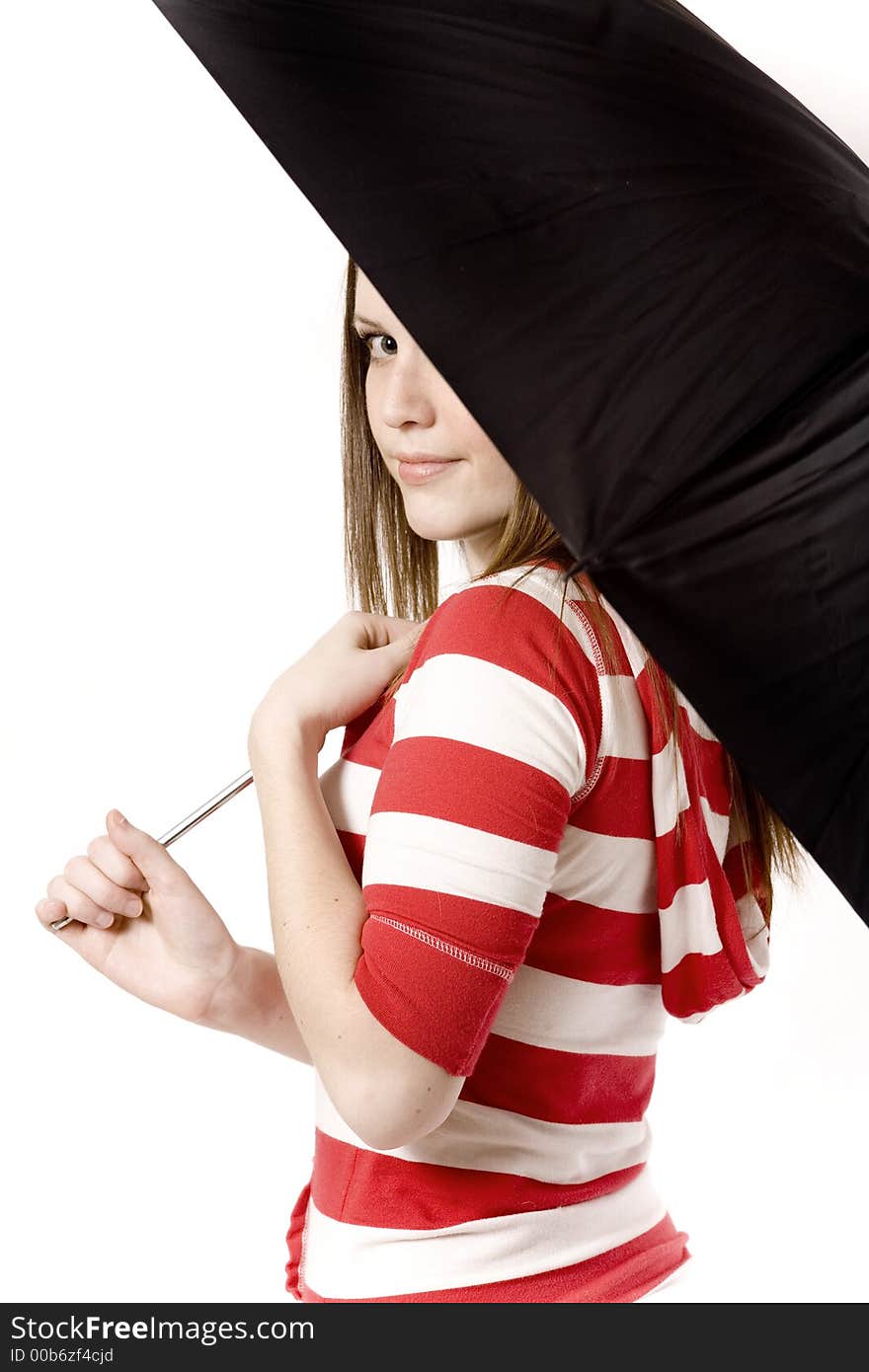 Woman looks back at the camera from an umbrella. Woman looks back at the camera from an umbrella