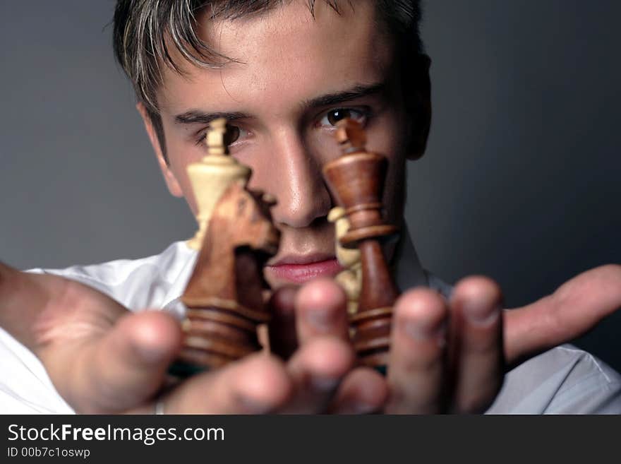 Very handsome young man concentrating on chess figures. Very handsome young man concentrating on chess figures