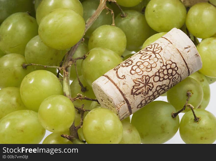 Grapes and a wine cork over white. Grapes and a wine cork over white