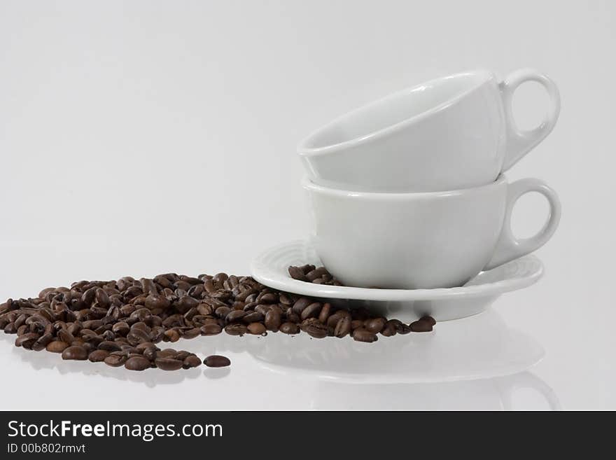 Two white cups with coffee-beans. Two white cups with coffee-beans