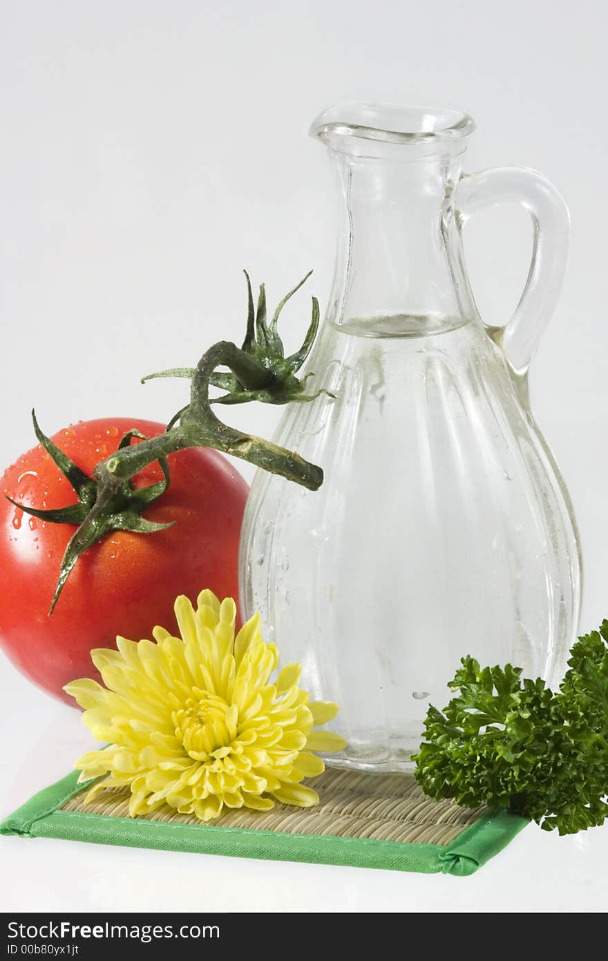 Tomatoes, yellow flower, parsley and decanter with water over white. Tomatoes, yellow flower, parsley and decanter with water over white