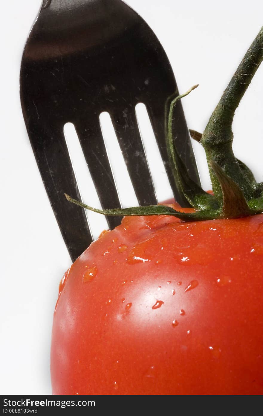 Fork put into in to tomato, close up