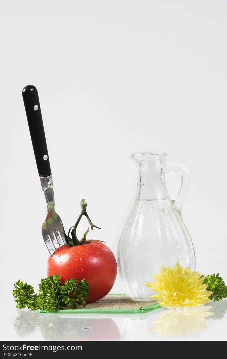 Tomatoes, yellow flower, parsley and decanter with water over white. Tomatoes, yellow flower, parsley and decanter with water over white