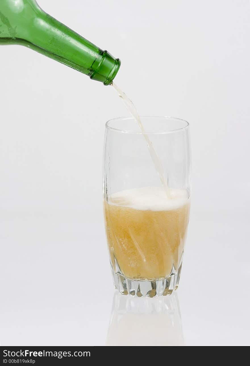 Beer pouring into glass on a white background